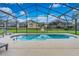 A screened-in pool features pristine blue water and a relaxing backyard view at 503 Balmoral Dr, Davenport, FL 33896