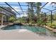 Screened-in pool with a waterfall feature and lush tropical landscaping at 3499 Rockcliff Pl, Longwood, FL 32779