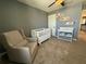 Neutral Bedroom featuring a crib, comfy chair, changing table, and bookshelves for an organized space at 2346 Upland Ln, Apopka, FL 32712