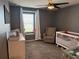 Cozy Bedroom featuring a crib, a glider chair, and a dresser with a window view at 2346 Upland Ln, Apopka, FL 32712