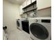 Functional laundry room with modern appliances, ample shelving, and overhead storage for convenience at 2346 Upland Ln, Apopka, FL 32712