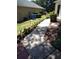 Nicely landscaped side yard showcasing a paved walkway bordered by garden beds and solar lighting at 2377 Paulette Dr, Haines City, FL 33844