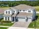Spacious two-story home featuring a three-car garage, manicured lawn, and a dense forest in the background at 3198 Sailing Pier Ave, Winter Garden, FL 34787