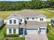 Spacious two-story home featuring a three-car garage, manicured lawn, and a dense forest in the background at 3198 Sailing Pier Ave, Winter Garden, FL 34787
