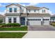 Two-story home with a three-car garage, brick paver driveway, manicured lawn, and wreath on the front door at 3198 Sailing Pier Ave, Winter Garden, FL 34787