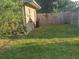 View of the exterior with a grassy yard and wooden fence at 108 5Th Jpv St, Winter Haven, FL 33880