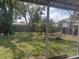 Large, grassy back yard with mature trees and a wooden fence at 108 5Th Jpv St, Winter Haven, FL 33880