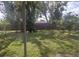 Large, grassy back yard with mature trees and a wooden fence at 108 5Th Jpv St, Winter Haven, FL 33880