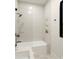 Modern bathroom with shower-tub combo, white tile, and a built-in shelf with recessed lighting at 110 W Railway Ave, Oakland, FL 34760