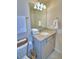Bright bathroom with a granite vanity, decorative mirror, and ample storage beneath the sink at 1687 Kona Ln, Davenport, FL 33897