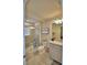 Well-lit bathroom with glass-enclosed shower, granite vanity, and neutral tile flooring at 1687 Kona Ln, Davenport, FL 33897