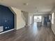 Open-concept living room with modern flooring, a painted accent wall, and sliding glass doors to the pool area at 1687 Kona Ln, Davenport, FL 33897