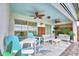 Inviting screened-in patio with blue furniture, ceiling fans, and an outdoor rug at 1687 Kona Ln, Davenport, FL 33897