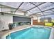 A screened-in pool and hot tub with an automatic shade over the outdoor kitchen and seating area at 1687 Kona Ln, Davenport, FL 33897