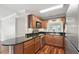 Kitchen featuring dark countertops and wood cabinetry, complete with stainless steel appliances and hardwood floors at 4878 Conway Rd # 91, Orlando, FL 32812
