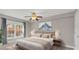 Cozy bedroom with a ceiling fan, plush bed, and a sun-drenched window view at 4878 Conway Rd # 91, Orlando, FL 32812