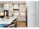 Bright kitchen featuring white cabinetry, marble countertops, stainless steel appliances and pendant lighting at 70 Millholland St, Oakland, FL 34760