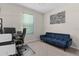 Comfortable room featuring a blue couch and a dedicated workspace at 10204 Spring Lake Dr, Clermont, FL 34711