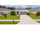 Exterior view of a single-Gathering home with a well-manicured lawn and two-car garage at 10204 Spring Lake Dr, Clermont, FL 34711