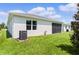 Exterior view of a home with a screened-in patio, showcasing well-maintained lawn and landscaping at 10204 Spring Lake Dr, Clermont, FL 34711