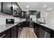 View of kitchen with stainless steel appliances, dark cabinets, and granite countertops at 10204 Spring Lake Dr, Clermont, FL 34711