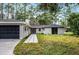 Newly renovated home with a black garage door and walkway at 14315 Conifer Dr, Orlando, FL 32832