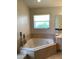 Bathroom showcasing a soaking tub, vanity, accent wall, and neutral tones at 2717 Bayview Dr, Eustis, FL 32726