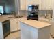 Well-equipped kitchen with stainless steel appliances, white cabinets and functional center island at 2717 Bayview Dr, Eustis, FL 32726
