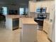 Bright kitchen features white cabinetry, stainless steel appliances and a cozy island at 2717 Bayview Dr, Eustis, FL 32726