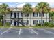 Two-story condo complex with blue shutters, black staircases, and palm tree landscaping at 3651 N Goldenrod Rd # 204, Winter Park, FL 32792