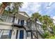 Exterior of a condo building with blue shutters and a staircase leading to upper units at 3651 N Goldenrod Rd # 204, Winter Park, FL 32792