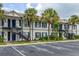 Condo complex with blue shutters and balcony stairs, surrounded by palm trees and landscaping at 3651 N Goldenrod Rd # 204, Winter Park, FL 32792