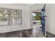 Bright living room with a window, wood-look vinyl plank flooring, and an open entry door at 3651 N Goldenrod Rd # 204, Winter Park, FL 32792