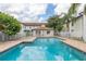 Community swimming pool surrounded by a brick patio and white picket fence at 3651 N Goldenrod Rd # 204, Winter Park, FL 32792