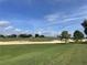 View of a green golf course with sand traps under a clear sky at 34001 Fortunado St, Sorrento, FL 32776