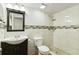 Modern bathroom with white tile, a dark vanity, and a walk-in shower offers a clean and functional space at 685 Chelsea Rd, Longwood, FL 32750