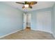 Bedroom with light blue walls, wood-look tile flooring, ceiling fan, and closet at 685 Chelsea Rd, Longwood, FL 32750