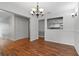 Bright dining room with rich hardwood flooring, chandelier lighting, and pass-through window to the kitchen at 685 Chelsea Rd, Longwood, FL 32750