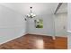 Empty dining room with chandelier, decorative walls, wood flooring, and view of the front yard at 685 Chelsea Rd, Longwood, FL 32750