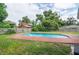 Backyard view of a private swimming pool with brick trim, surrounded by lush landscaping and privacy fence at 685 Chelsea Rd, Longwood, FL 32750