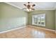 Bedroom with neutral green walls, ceramic tile floors, and a shuttered window at 1730 Stafford Springs Blvd, Mount Dora, FL 32757