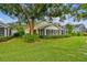 Charming home exterior featuring lush landscaping and an inviting screened-in porch, perfect for relaxing at 1730 Stafford Springs Blvd, Mount Dora, FL 32757