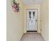 Close-up of the front door entrance, showing a white door with a decorative wreath on the textured wall at 1730 Stafford Springs Blvd, Mount Dora, FL 32757