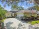 Charming single-story home with a well-manicured front yard, flowering plants, and a driveway leading to a two-car garage at 1730 Stafford Springs Blvd, Mount Dora, FL 32757