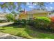 Beautifully landscaped front yard with lush green grass, colorful plants, and a well-maintained lawn at 1730 Stafford Springs Blvd, Mount Dora, FL 32757