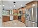 Well-lit kitchen features stainless steel appliances, natural wood cabinets, and tile flooring at 1730 Stafford Springs Blvd, Mount Dora, FL 32757