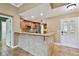 Open kitchen view featuring a breakfast bar with tile accents, stainless steel appliances, and tiled flooring at 1730 Stafford Springs Blvd, Mount Dora, FL 32757