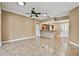 Open concept living room with tile flooring, ceiling fan and view into the kitchen at 1730 Stafford Springs Blvd, Mount Dora, FL 32757