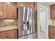 Stainless steel refrigerator with water dispenser in kitchen with wooden cabinets and tile countertop at 1730 Stafford Springs Blvd, Mount Dora, FL 32757
