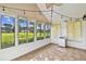 Light-filled sunroom with large windows showcasing views of the green landscape and golf course at 1730 Stafford Springs Blvd, Mount Dora, FL 32757